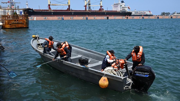 Angkatan Laut Meksiko bekerja secara manual untuk membersihkan area pantai yang terkena dampak tumpahan minyak.